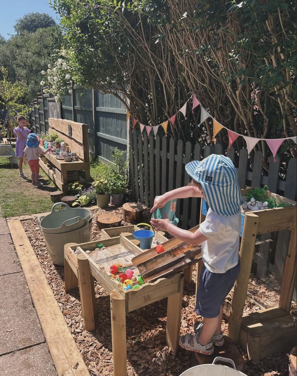 Children enjoying the water play tables in the garden